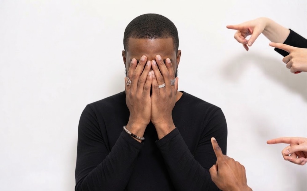 Salarié se cachant le visage, montré du doigt par d'autres